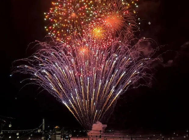 Fuegos artificiales frente al mar con invitados